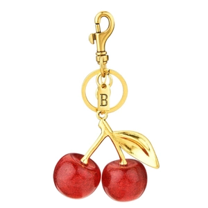 Sparkly red cherry keychain with gold metal leaves and a round letter B pendant tag