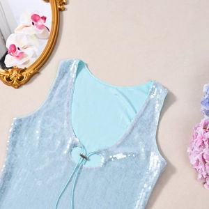 Détail macro du haut à paillettes avec col en V, boucle métallique et tissu bleu clair