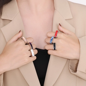 Detail view of colorful geometric square glass gemstone rings on a model hand