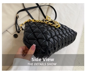 Detailed side view of black quilted shell bag with gold chain and thick padding