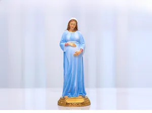 Detailed view of pregnant Mary statue with blue robe and floral gold base decor