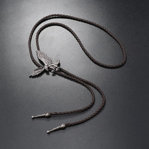 Detailed close-up of eagle bolo tie with vintage silver pendant and brown leather cord