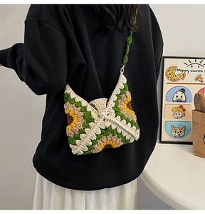 Detailed knit texture of handmade sunflower crochet shoulder bag worn by a model
