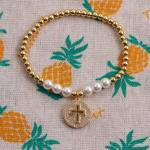 Detail von Goldperlen und weißen Perlen Armband mit funkelndem Mikro-Pave-Kreuzanhänger
