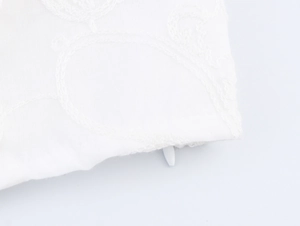 Détail du haut court en dentelle blanche avec broderie fine et fermeture éclair invisible