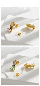Close-up of fishtail earrings with gold plating and colorful cubic zirconia stones
