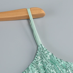 Detailed view of mint green sequins and delicate shoulder strap on a party dress