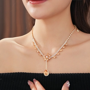 Close-up of champagne zircon flower necklace with drop pendant on model's neck