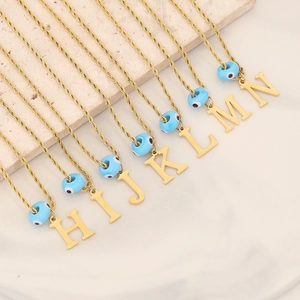 Golden twist chain necklaces with alphabet pendants and blue evil eye charms on stone