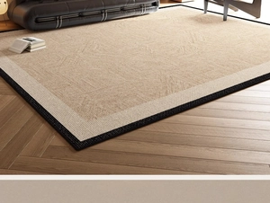Detail view of woven jute rug with wide black border on wooden floor in living room