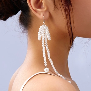 Side view of multi-layered pearl tassel earrings worn by a model in soft lighting