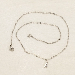 Detailed close-up of silver letter A pendant on a fine stainless steel chain necklace