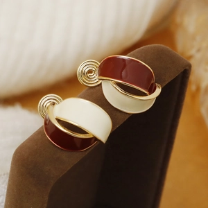 French vintage pearl enamel clip-on earrings in deep red and cream on velvet stand