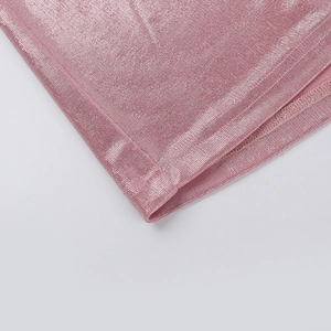 Dettaglio del tessuto metallico rosa dell'abito con texture e cuciture precise