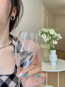 Close-up of silver-tone irregular C-shaped earrings worn by a model in a cozy indoor setting