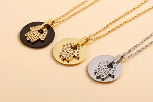 Detailed close-up of Hamsa Hand pendants in gold, silver and black with sparkling rhinestones