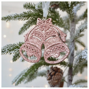 Close-up of rose gold Christmas bell ornaments with glitter on snowy pine branches