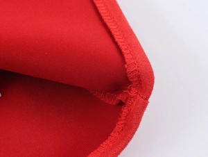 Détail de la texture en maille suédine rouge et de la finition de couture surjetée