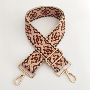 Detail of ethnic geometric jacquard bag strap with golden lobster clasps and adjuster