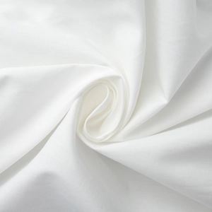 Détail du tissu en coton blanc montrant la texture douce et le drapé en spirale fluide