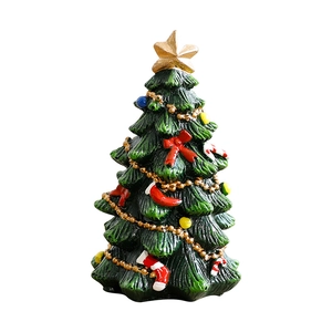 Mini resin Christmas tree with gold star red bows and ornaments on white background