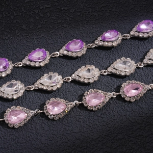 Vue détaillée de pendentifs en strass goutte d'eau en couleurs violet, rose et blanc