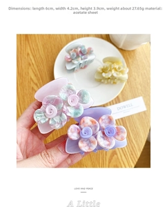Detail of four acetate camellia hair claws showing marble texture and soft pastel colors