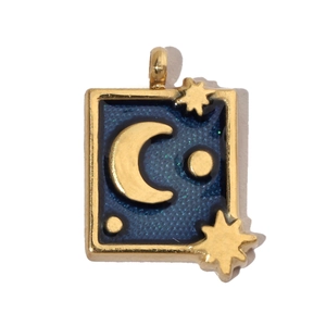 Detailed macro view of a vintage rectangular gold pendant with a blue moon and stars