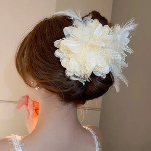 Detail of cream white lace and feather flower hair claw clip with delicate pearl accents