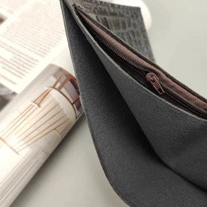Detailed macro view of the interior zipper pocket and crocodile texture of the wallet