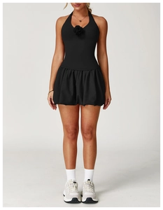 Detail of a black tennis dress with a 3D rose accent on the halter V-neckline