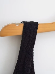 Gros plan des bretelles tissées noires et détails de tissu sur une robe en maille