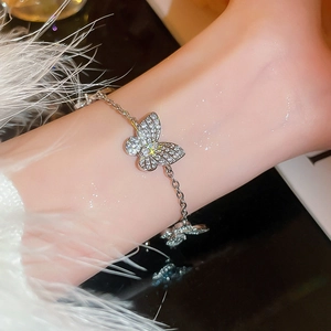 Detailed view of a silver butterfly bracelet with shimmering zircons worn on a wrist