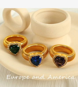 Detailed macro view of three gold textured rings with colorful heart shaped gemstones