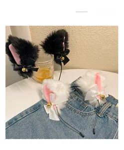 Detail view of plush cat ears headband with satin bows and golden bells on denim