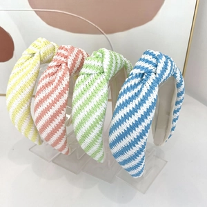Détail de serre-têtes larges à nœuds tressés en jaune, rose, vert et bleu d'été
