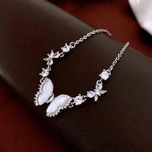 Macro shot of silver butterfly bracelet featuring mother of pearl and zircon details