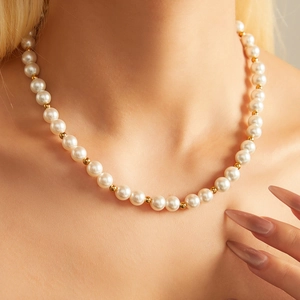 Close-up of pearl and gold bead choker necklace worn on a neck for elegant styling