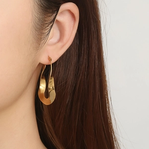 Chic 18K gold plated stainless steel twisted flat earrings worn by a model in profile