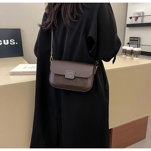Detail of dark brown leather and suede crossbody bag with vintage square buckle accent