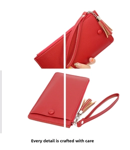 Macro view of red lychee grain leather wallet with tassel charm and zip closure