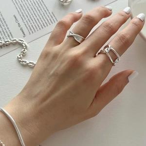 Close-up of a 925 sterling silver Mobius ring and chain link ring set on a hand