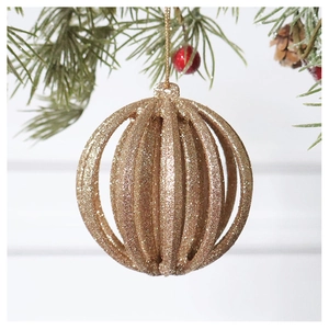 Champagne gold Christmas ball with hollow vertical stripes and glitter on a pine branch