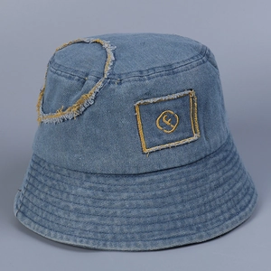 Detail of light blue denim bucket hat featuring F-letter embroidery and distressed edge