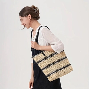 Large striped straw tote bag with black shoulder straps for summer beach vacation