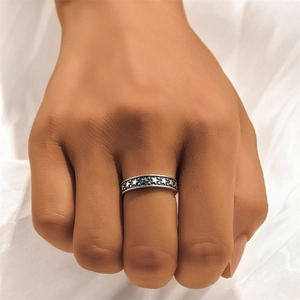 Macro shot of a vintage silver ring with embossed star patterns worn on a finger