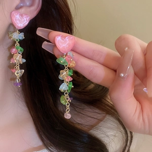 Détail de boucles d'oreilles cœur avec pampilles en pierres colorées semi-précieuses
