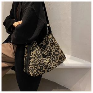 Lifestyle shot of leopard print canvas tote bag with wide black strap on model