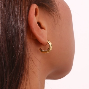 Close-up of 18K gold plated C-shaped earring with colorful zircon stars worn by a model
