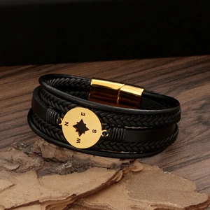 Macro view of men's leather bracelet with gold compass charm and magnetic clasp